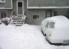 The front steps have been shovelled; part of the car is clear.