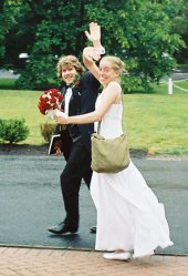 The groom and bride wave goodbye.