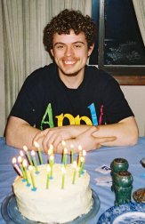 Kevin faces his lighted birthday cake.