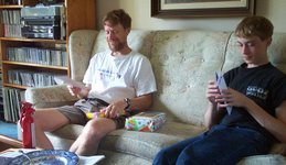 Scott on the sofa with packages, and Philip reading a card