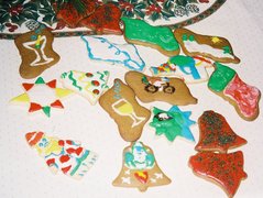 artistically decorated Christmas cookies including a Santa, a red stocking, a snowy hillside, and a snowman on a bicycle