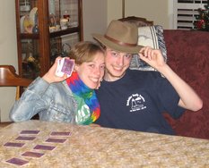 Jocelyn and Phil smile with the cards and headgear