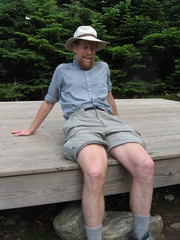 hiker sittig on a tent platform