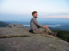 hiker on mountain top above a valley with fog